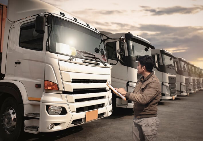 Man using field service management software to makes notes about his fleet of work trucks.