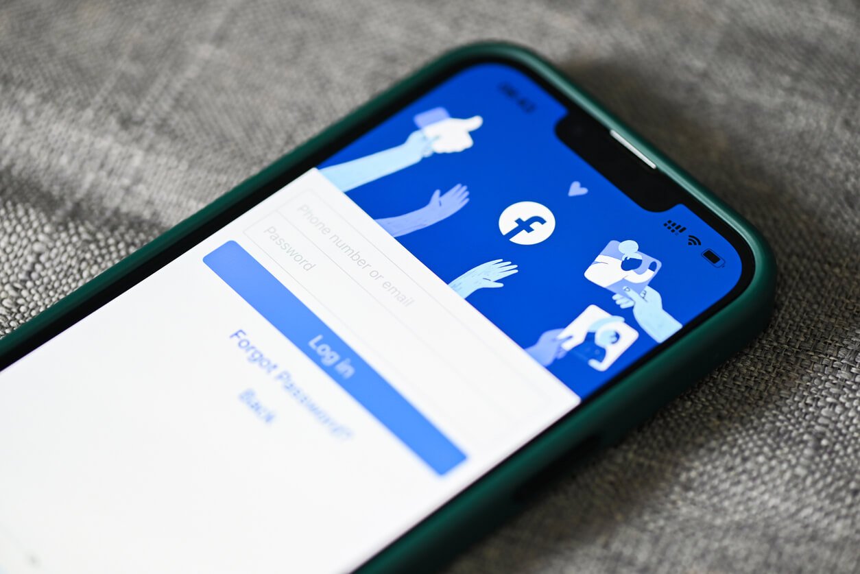 An iPhone with the Facebook app open on the login page.