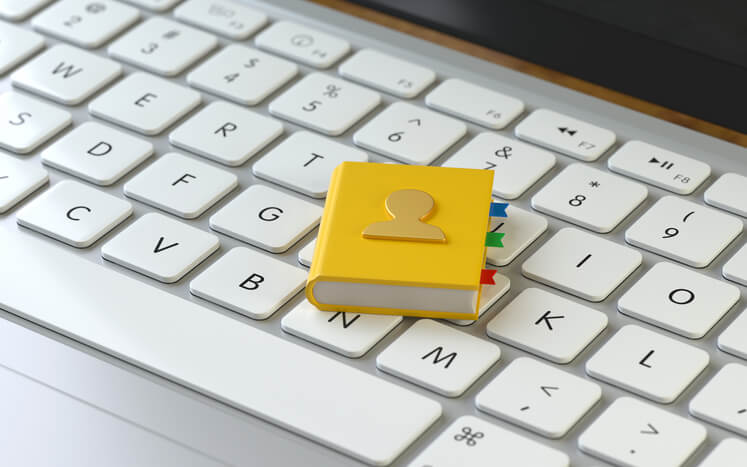Local business directory feature image that shows a mini local business directory sitting on top of a keyboard.